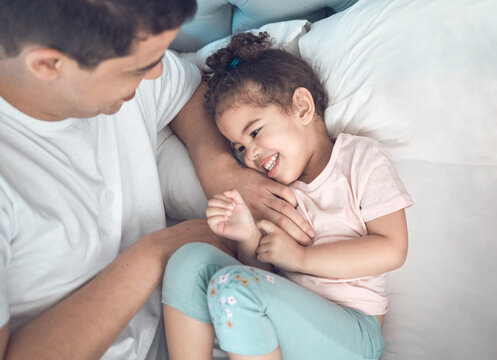 She is my bigger picture. Shot of a dad and daughter bonding in bed together.