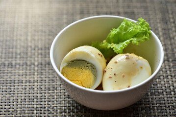 Hard-boiled eggs are placed in a white container with fresh lettuce. Healthy food concept. Increase protein. Weight control.