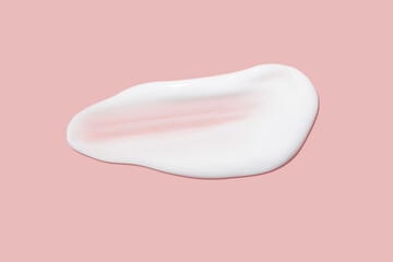 A dab of cosmetic cream. Light, smooth surface. Texture of spreadable cream. Liquid cream smear. On a pink background.