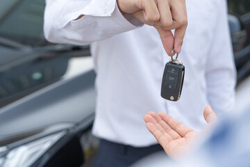 lease, rental car, sell, buy. Dealership manager send car keys to the new owner.  Sales, loan...