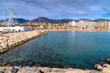 Fototapeta premium Benalmadena beach Playa de Fuente Salud with big wheel and view to mountains Spain Costa del Sol