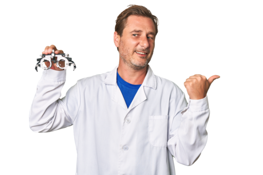 A middle-aged optometrist man points with thumb finger away, laughing and carefree.