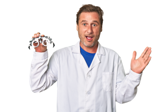 A middle-aged optometrist man receiving a pleasant surprise, excited and raising hands.