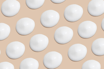 a set of strokes of white cream on a beige background.