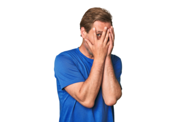 A middle-aged man isolated blink through fingers frightened and nervous.