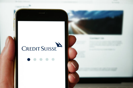 Lviv, Ukraine - 03 11 2023: Person holding mobile phone with logo of financial company Credit Suisse Group AG on screen in front of business web page.