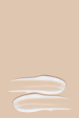 a set of strokes of white cream on a beige background.