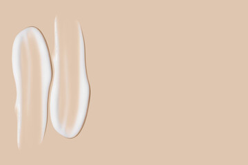 a set of strokes of white cream on a beige background.