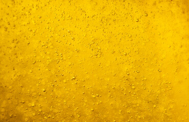 Air bubbles or bubbles of various sizes floating in a golden yellow liquid or gold background for use as wallpaper.