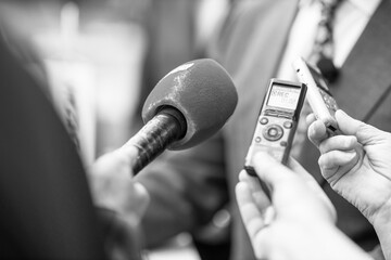 News or press conference or media interview, digital voice recorder and microphone in focus