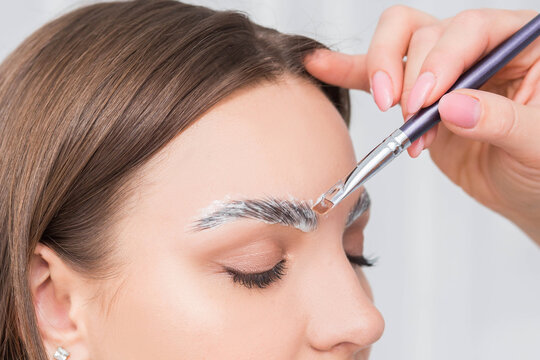 Process of long-lasting styling of the eyebrows and coloring the eyebrows. Eyebrow lamination. Professional make-up and face care.