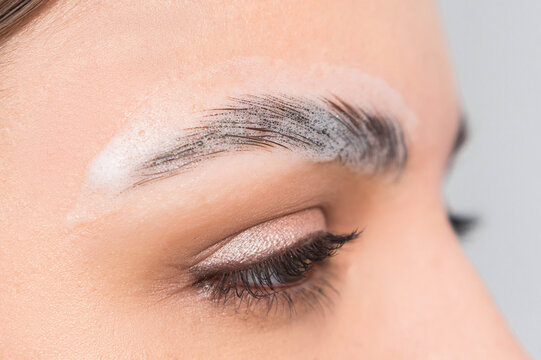 Macro of eyesbrows undergoing correction and long-lasting styling, shaping the eyebrows, eyebrows in foam. Selective focus, close up