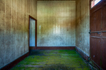 Interior de um amplo quarto vazio de uma casa de madeira abandonada