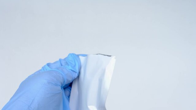 closeup female hands holding PCR test cassette, opens the package, assistant makes express test in medical scientific laboratory, stirs sample of genetic sample, concept of covid-19 infection