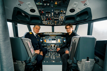 airplane cockpit pilot and young student boy smiling after training on flight simulator entertainment concept © Guys Who Shoot