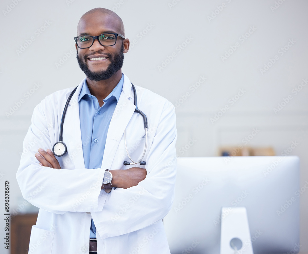 Wall mural the friendliest doctor around. shot of a young male doctor standing with his arms crossed in an offi