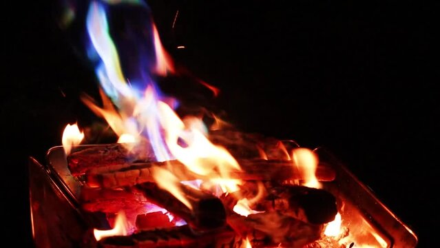 A picture of a rainbow-colored campfire at a camping site