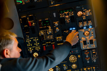 Fototapeta premium Airplane cabin The pilot checks the plane's electronics by pressing the buttons Preparing the passenger liner for takeoff