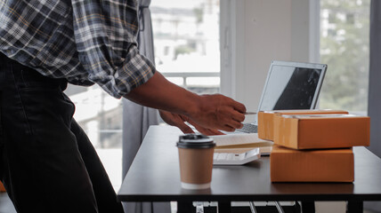 Entrepreneurs Small Business SME Independent men work at home Use smartphones and laptops for commercial checking, online marketing, packing boxes, SME sellers, concept, e-commerce tea