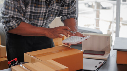 Entrepreneurs Small Business SME Independent men work at home Use smartphones and laptops for commercial checking, online marketing, packing boxes, SME sellers, concept, e-commerce tea