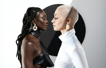 Fashion for the forward thinkers. Shot of two attractive young women posing against a wall with a black circle on it.