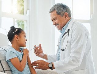 Fototapeta premium You wont feel a thing. Shot of a mature male doctor giving a little girl an injection during a checkup at home.