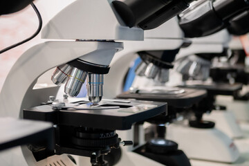 Professional microscopes with objective lenses in row at technology exhibition, trade show. Laboratory equipment, science, medical, optical, pharmaceutical and education concept