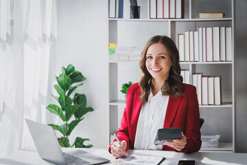 Happy Business woman entrepreneur holding calculator working sit at office desk. Portrait of beautiful smiling young businesswoman working at modern work station. - obrazy, fototapety, plakaty