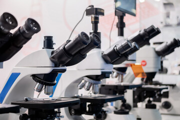 Professional microscopes in row at technology exhibition, trade show. Laboratory equipment, science, medical, optical, pharmaceutical and education concept