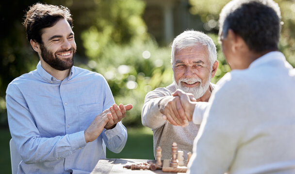 Friends put the mate in check mate. Shot of a group of men playing a game of chess outside. - Powered by Adobe