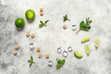 Mojito ingredient frame. Lime, mint leaves, cane sugar and ice cubes on a light stone background. Top view, flat lay.