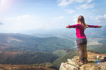 Naklejka premium Young woman n the top of the mountains