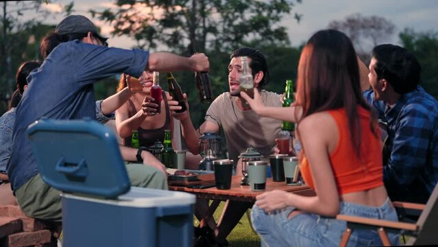 Happy young friends traveler group having fun and drink beer together in camping party, Group of multiculturalism hipster people enjoying holiday vacation trip in campsite