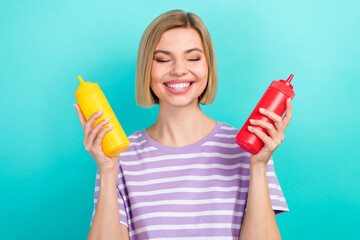 Photo of cheerful funny person bob hairdo trendy t-shirt cooking burger hold bottles of ketchup...