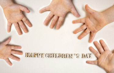 happy children's day words formed from eco wooden letters isolated with one or many kid child's hands from different parts of page.dirty small cute baby pre schooler kid palm.celebrate holiday june 1s