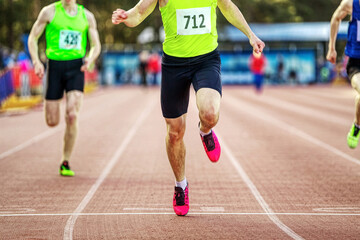 male athlete runner crosses finish line sprint race in athletics championships, close-up man...