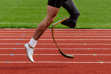 legs runner para-athlete on prosthesis running red track stadium, summer para athletics...