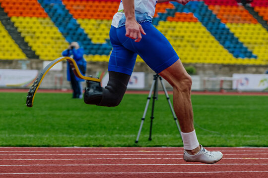 male runner para-athlete on prosthesis running track stadium, summer para athletics championships