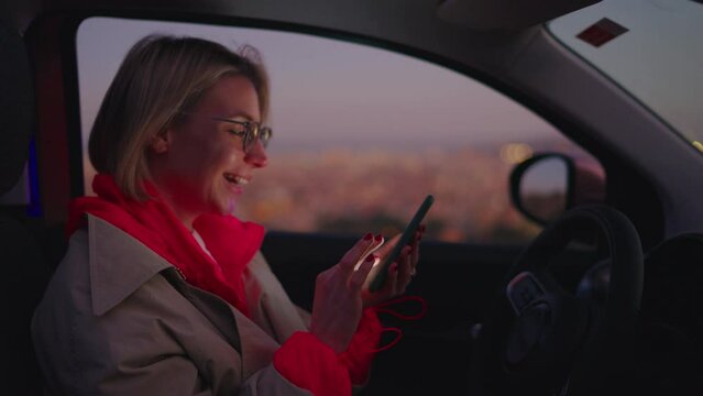 Young woman using smartphone to communicate with world through online content creation. Female blogger is influential user excitedly celebrating latest accomplishment in line of work while sits in ca