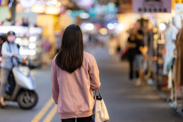 Woman walk into the street night market in Taipei