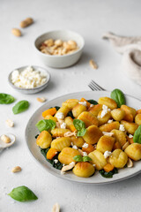 Fried Italian potato gnocchi with cheese and herbs on a white background. Italian food