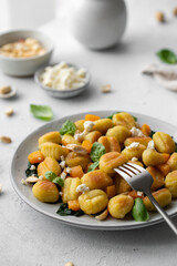 Fried Italian potato gnocchi with cheese and herbs on a white background. Italian food