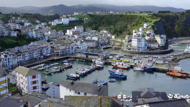 Fishing port with small fishing boats at the foot of the picturesque town of Luarca, Asturias