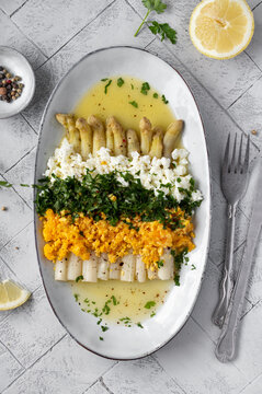 Freshly homemade white asparagus a la Flamande on a white plate. Flemish style white asparagus - with boiled eggs, parsley and hollandaise sauce