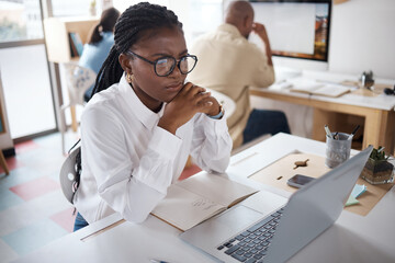 Ready to take on this day. Shot of a young businesswoman using a laptop in a modern office.