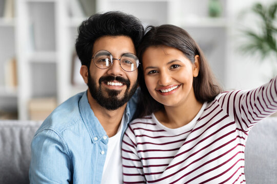 Happy cute young indian couple taking selfie at home
