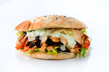 Flatbread with tomatoes, chicken, lettuce, cheese, olives, croutons and sauce on white background.
