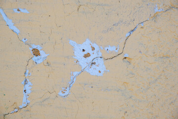 old plastered yellow wall with cracks