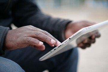 African american man uses tablet computer. Black man hands holds tablet pc