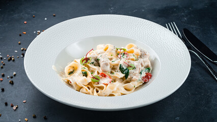 Lunch pasta with mushrooms, tomatoes, basil and cream sauce.